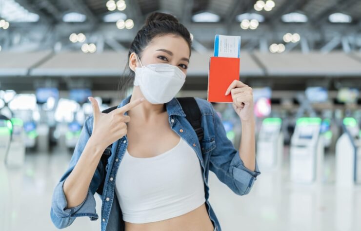 happiness-smiling-asian-adult-female-wear-face-mask-hand-gesture-showing-passport-blank-screen-smartphone-aitport-terminalasian-female-ready-travel-after-lockdown-ia-airport-min